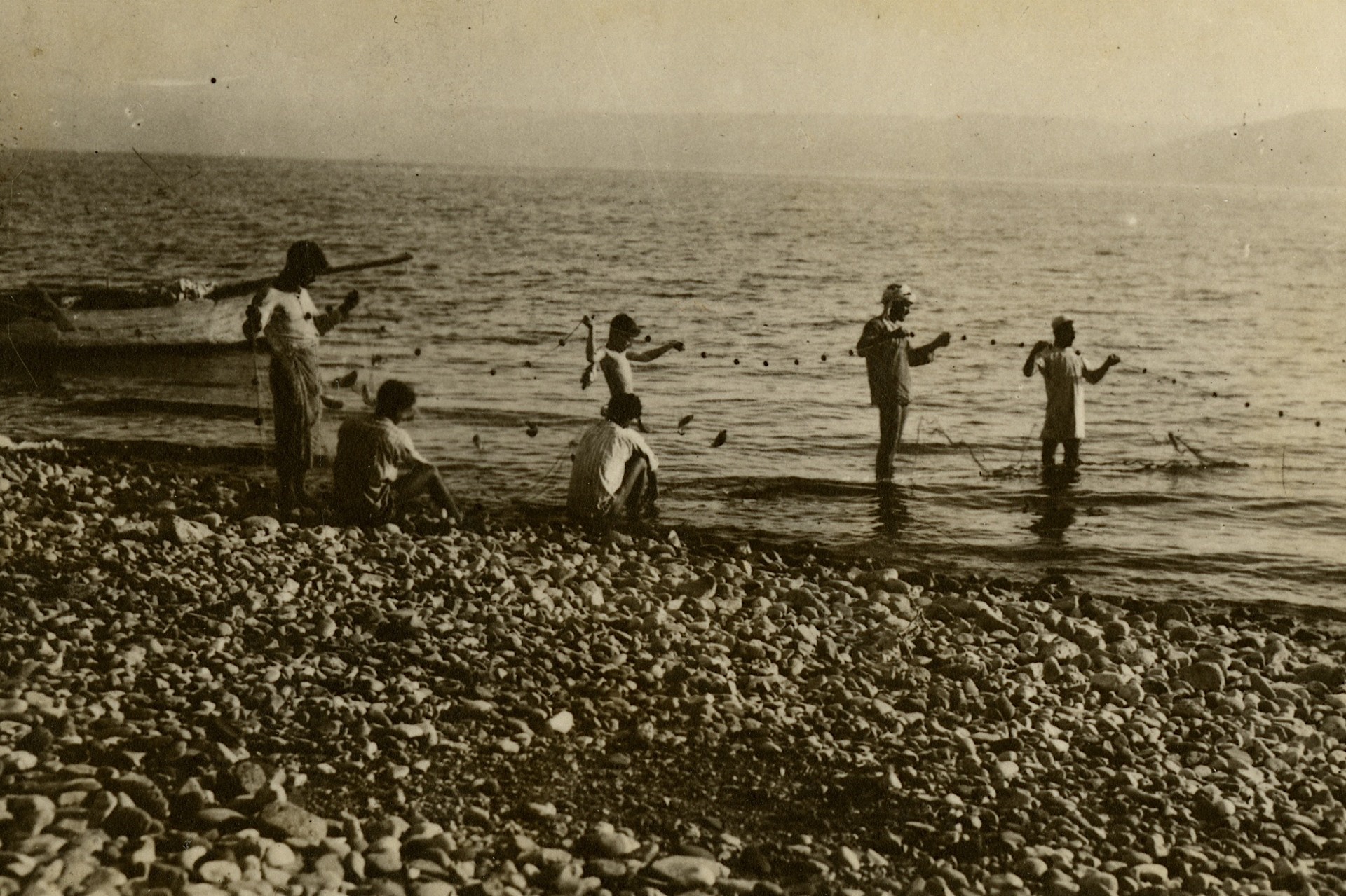 Fishermen throw nets into the sea.