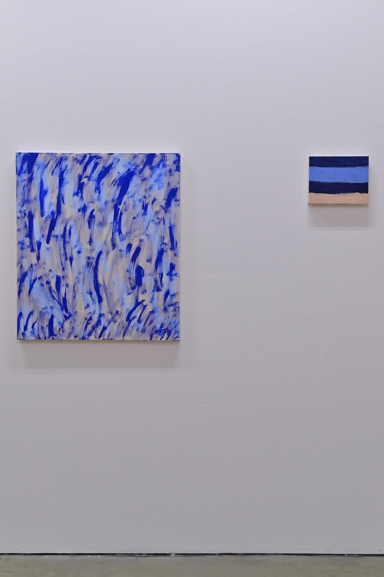 Painting with blue, pink, yellow, and green strokes on a white wall.