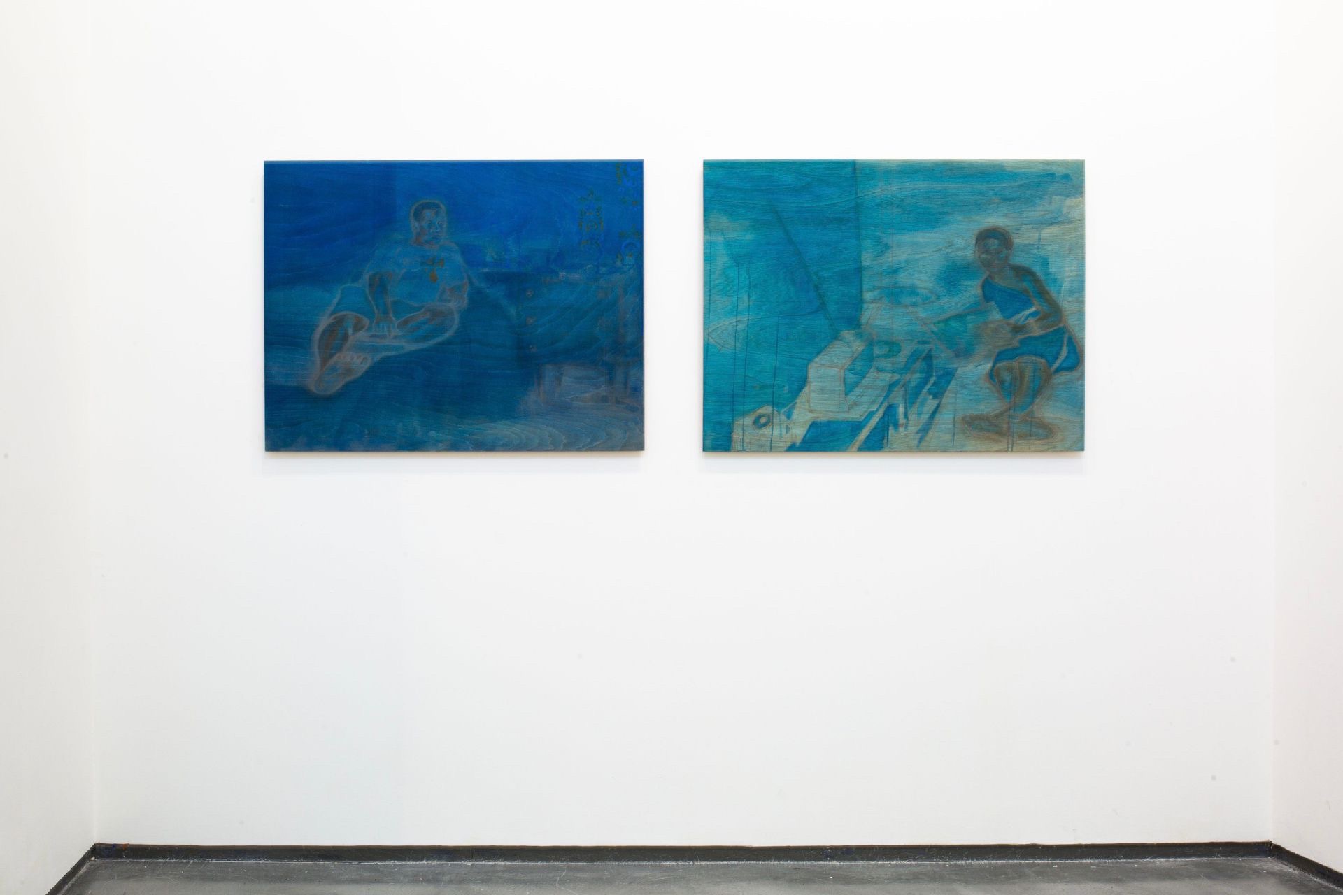 The work is a diptych, two paintings both including laying figures located in a stained blue bedroom. The figure on left seems to be reading a book while gazing back at the observer, the figure on the right isn't gazing at you but instead, he is looking at