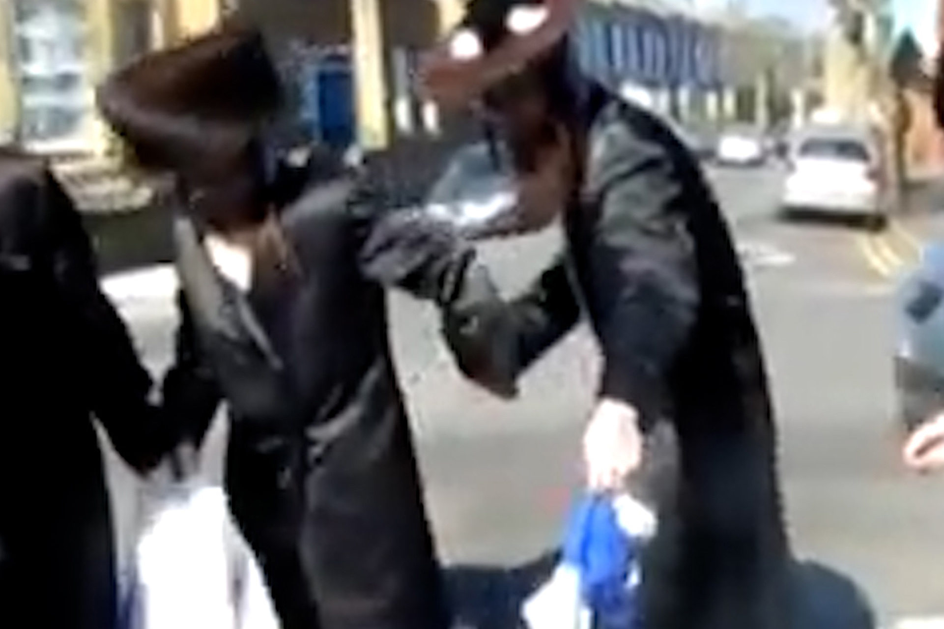 3 Ultra Orthodox Jews dancing in a circle.