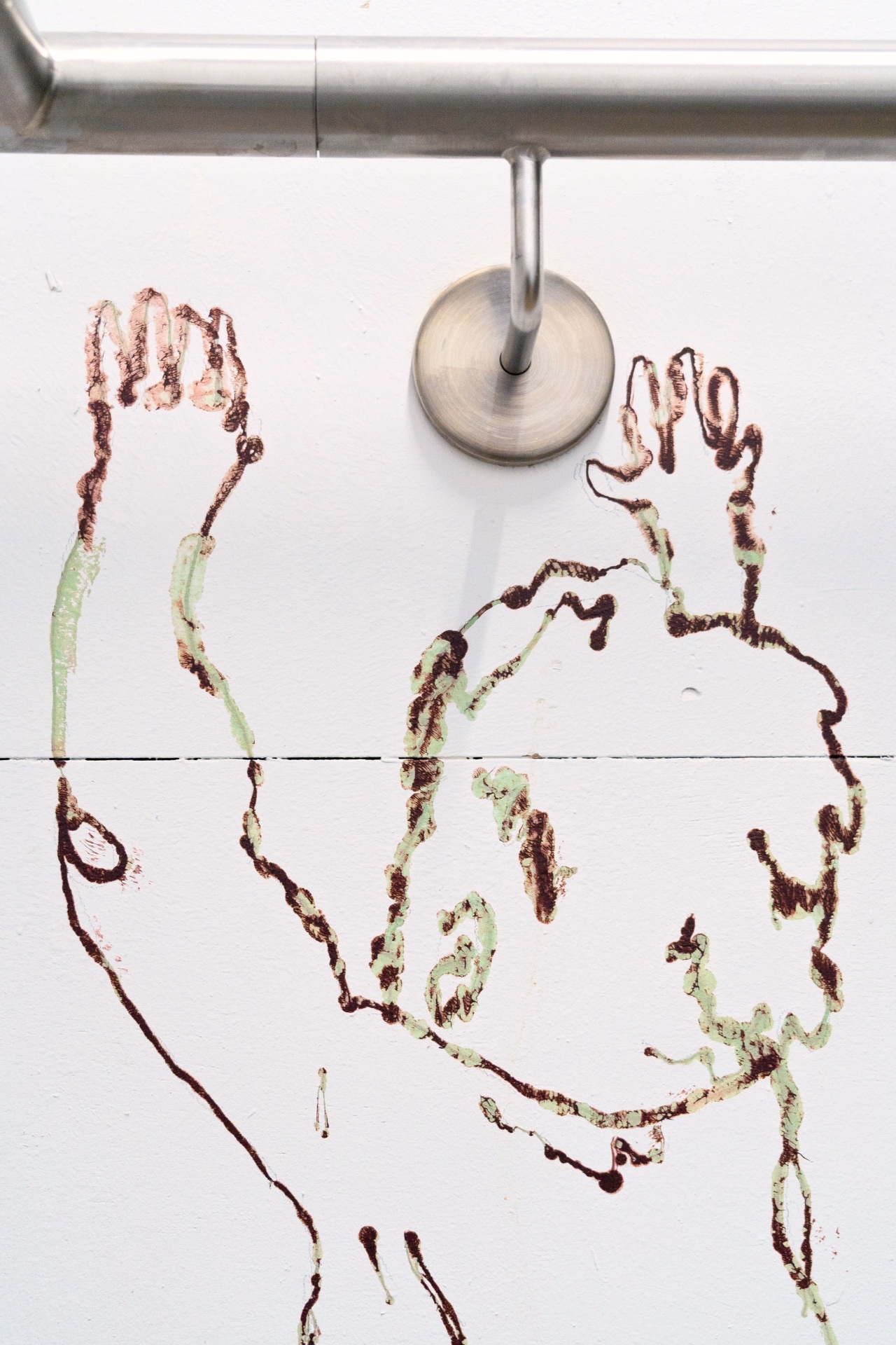 Figure with raised hands drawn in henna, reacting chemically with wall paint to leave green marks.