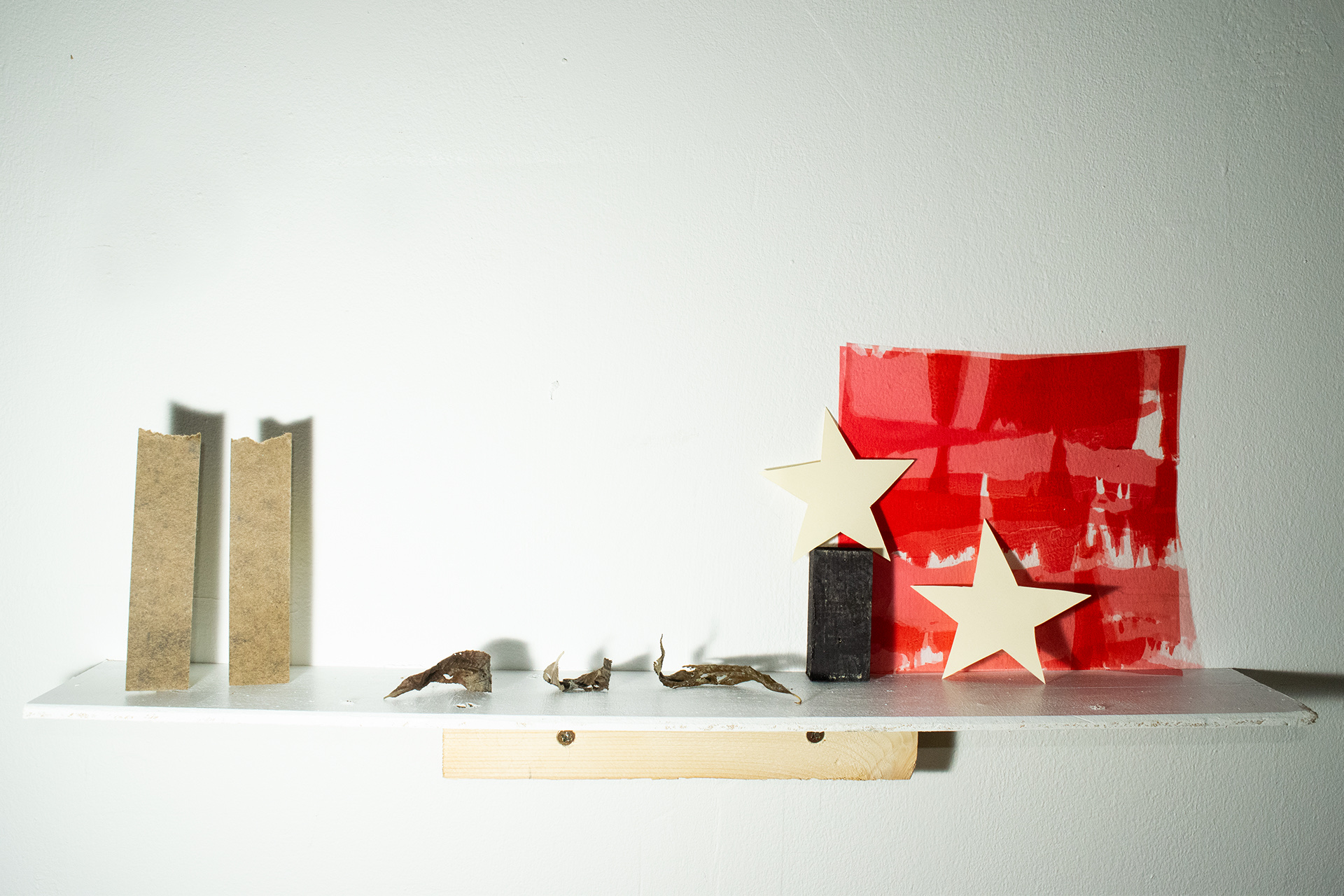Stars, red lighting gel, willow leaves and paper forms complete a folkloric assemblage.