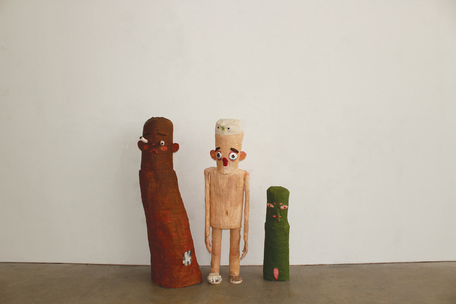 Three sculptures of strange children made with chicken wire, plaster and paint.
