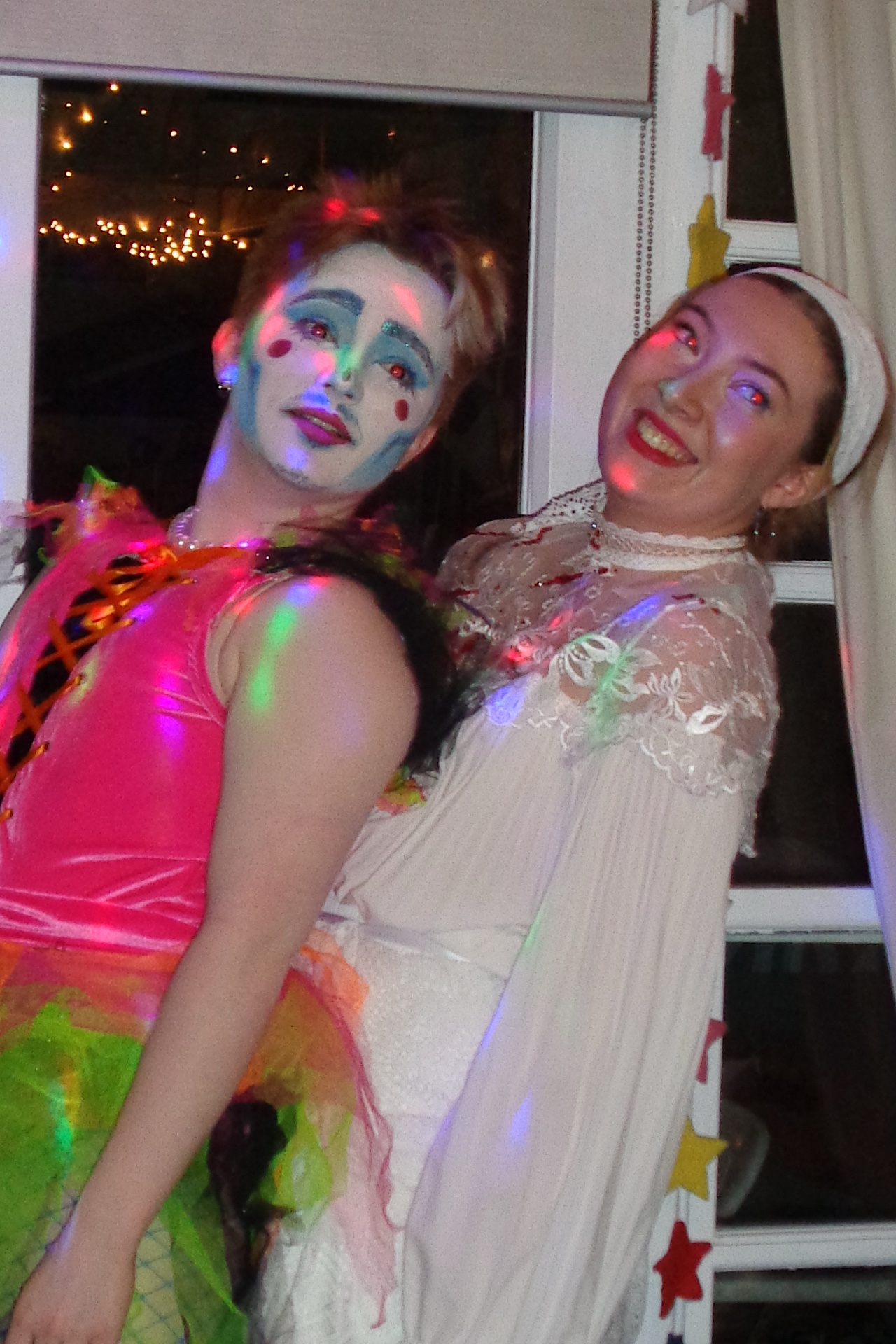 A photograph of two performers in vibrant outfits in the middle of a scene