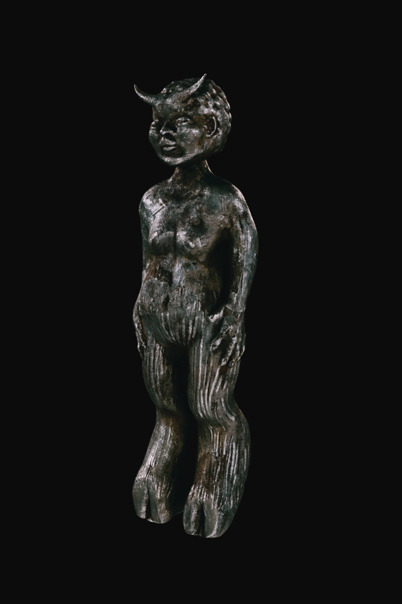 A metallic statuette of a horned figure.