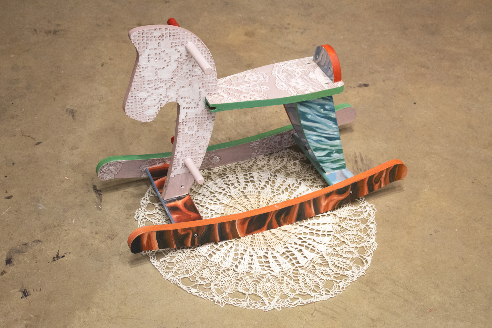 A rocking horse, sat on a doily, with oil painted doily, water, velvet curtain and bedsheet textures spanning its surface