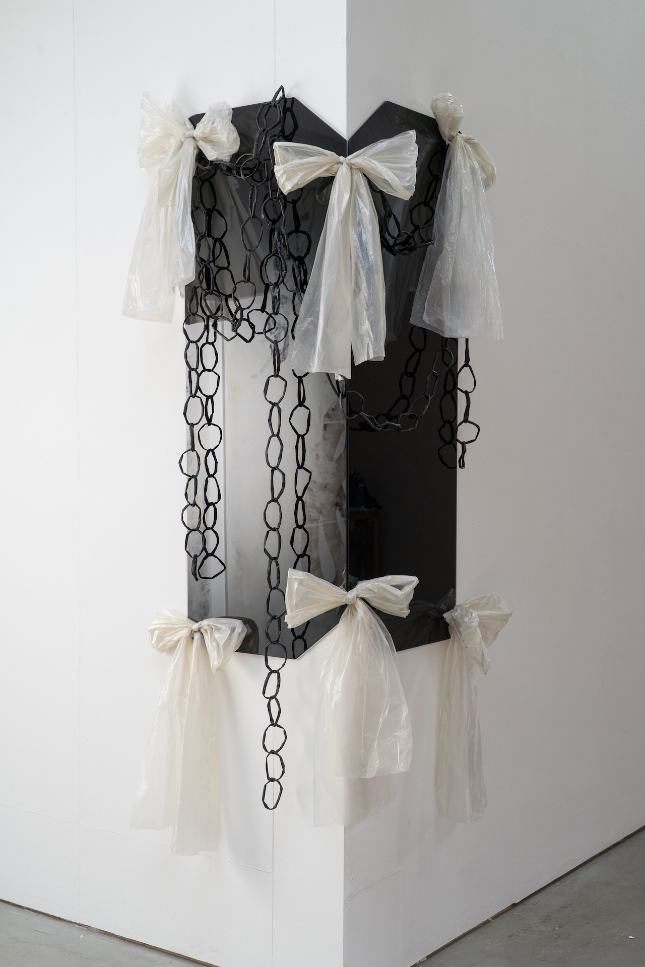 Collaged image of brown, yellow, white and blue on board with daisy chain black straws hanging halfway down the right side.