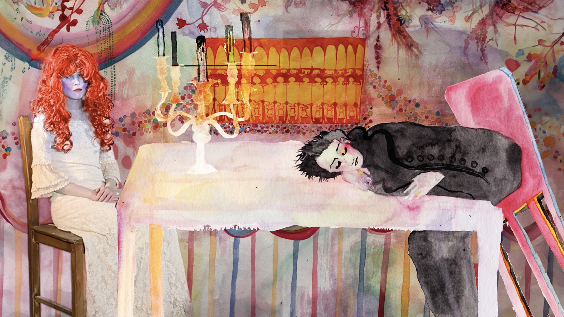 A video still featuring the artist dressed in a long lace dress and saturated red wig, with theatrical makeup- a white face with red cheeks- gazing downwards, appearing dejected as she sits on a chair in a composited pastel-coloured watercolour room, at a 