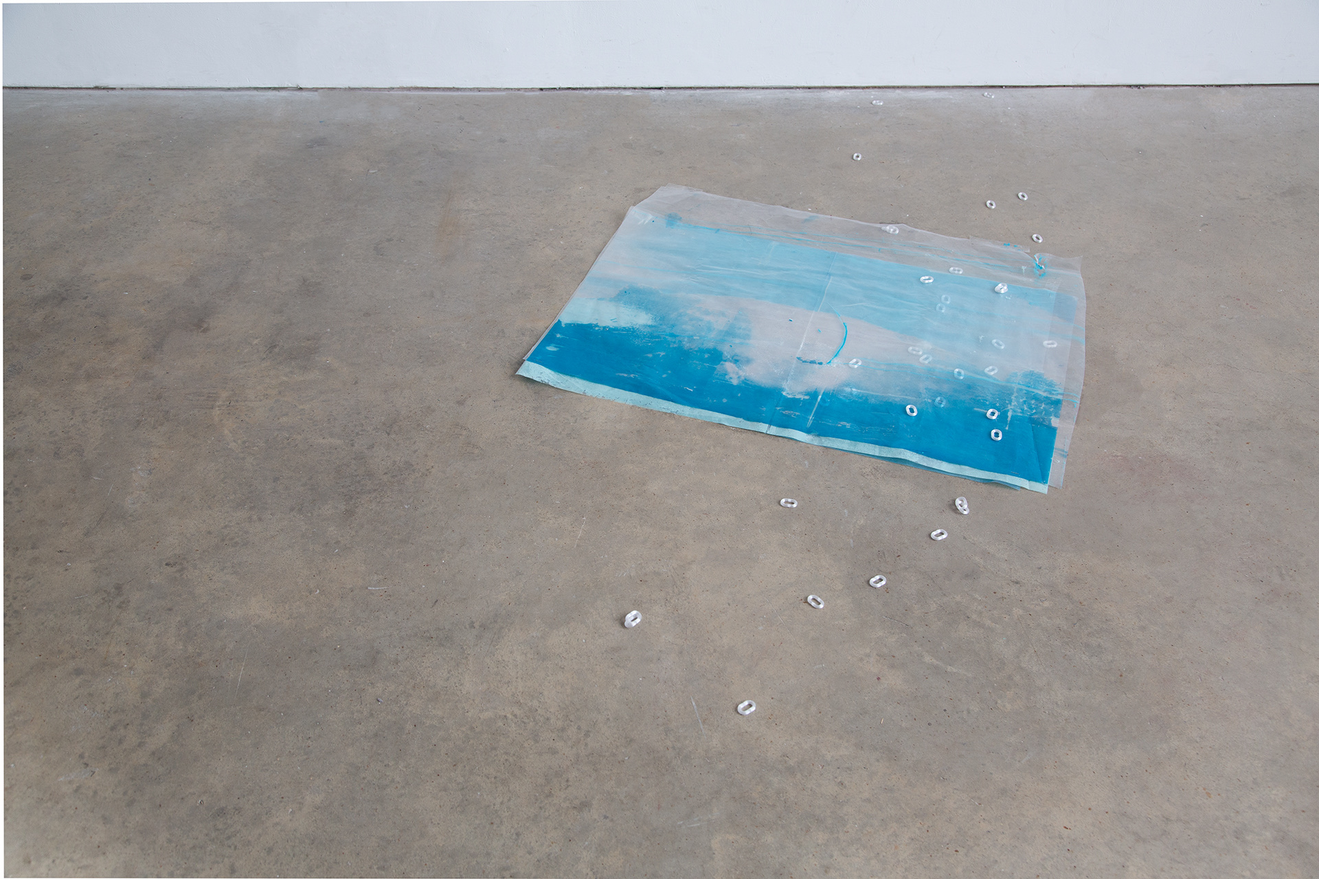 Blue toned screen print on acetate, arranged on concrete floor with iridescent 3d printed chain links. 