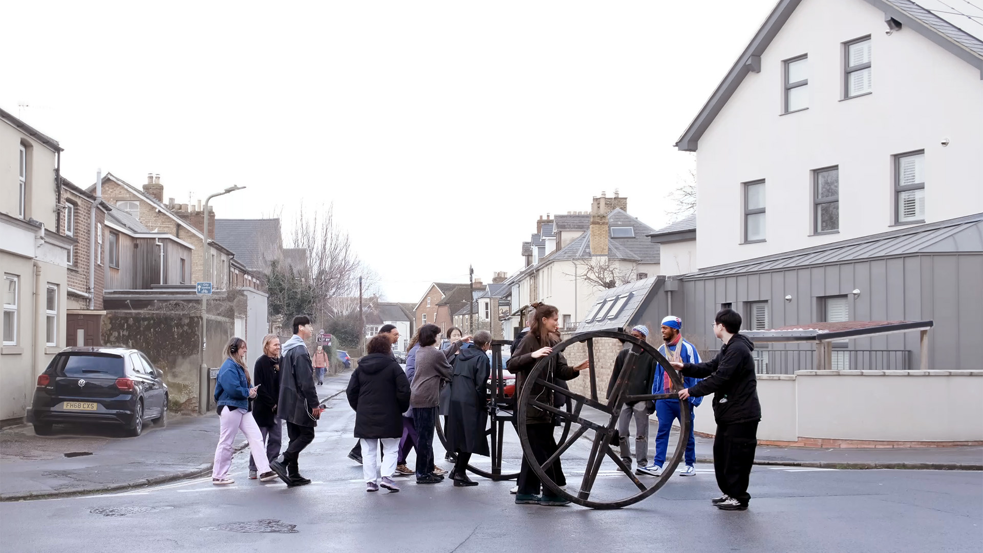 Two bell wheels walked down Bullingdon Road by 19 students on a cloudy day.