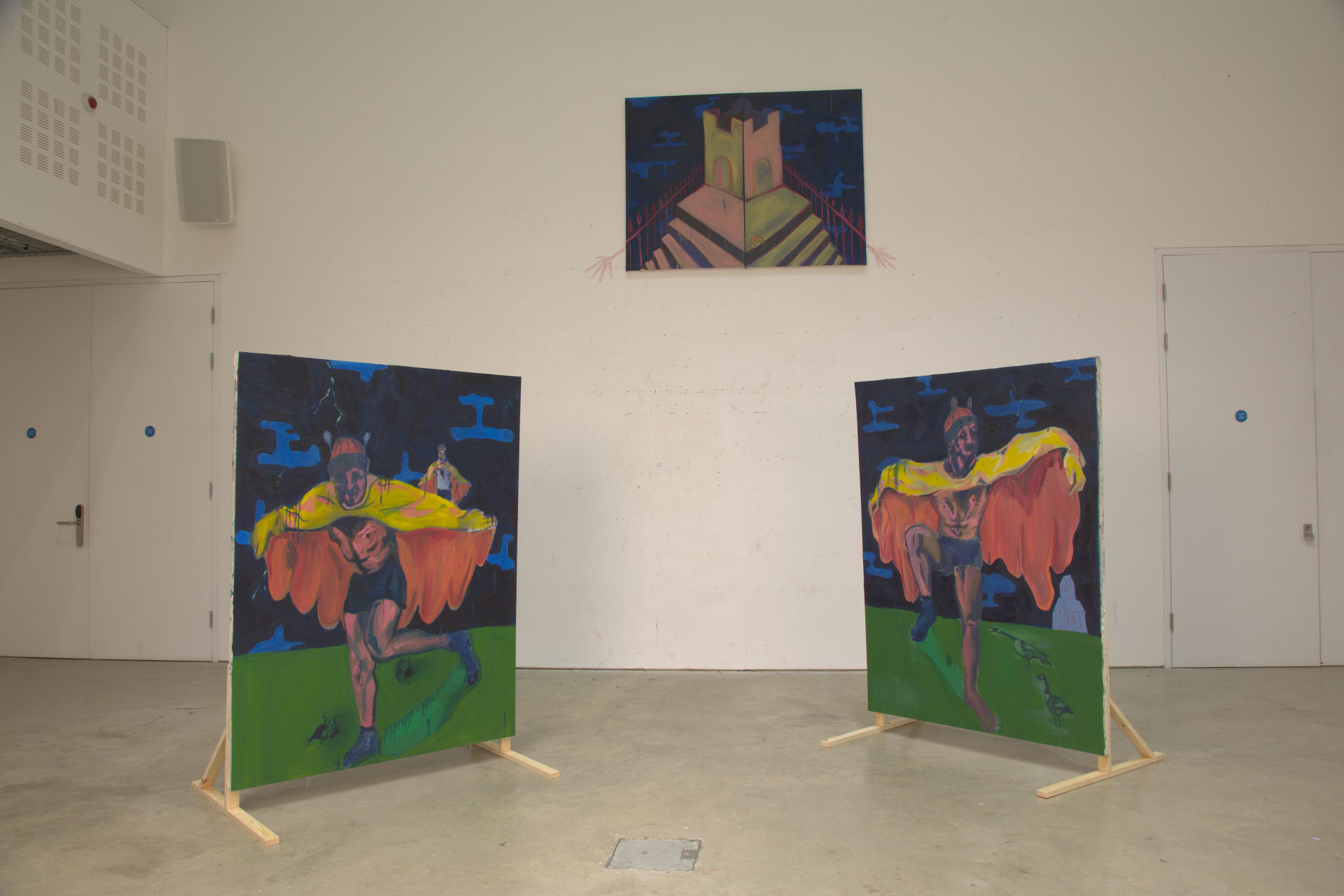 Three paintings, two on legs and a diptych high up on the wall of silly boys trying to fly to a castle in the sky.