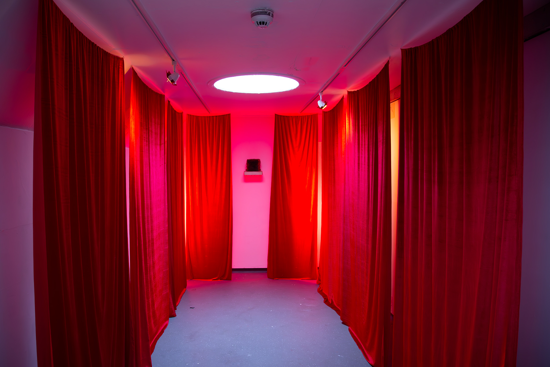 Long room lined with red velvet curtains