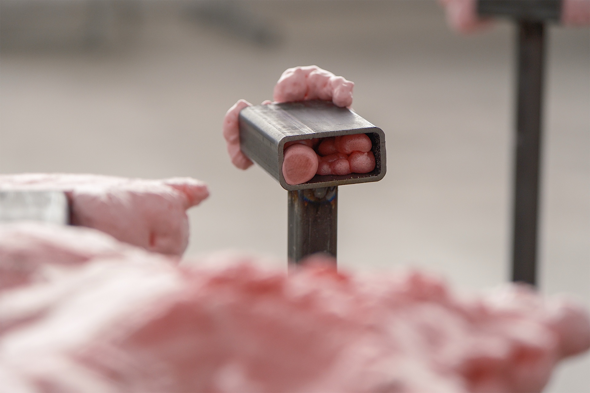 Installation in a bathroom featuring a pink foam sculpture resting inside a sink